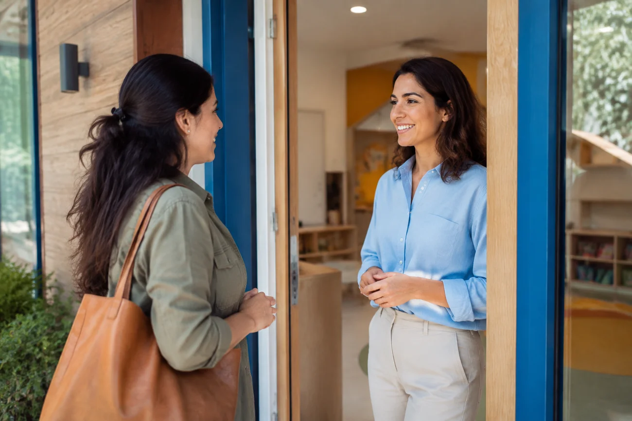 A teacher and a parent talking at the school entrance